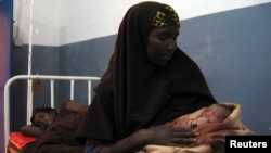 A Somali woman holds a newborn baby at a hospital run by Doctors Without Borders, Jowhar, north of Mogadishu, Aug. 3, 2007.