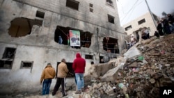 Palestinians gather by a destroyed house of Raeb Ahmed Muhammad Alivi that was demolished by the Israeli army in the West Bank city of Nablus, Thursday, Dec. 3, 2015.