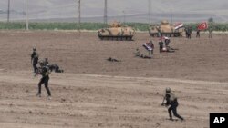 Turkish and Iraqi soldiers walk with Turkish tanks during the exercises in Silopi, near the Habur border gate with Iraq, southeastern Turkey, Sept. 26, 2017. 