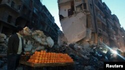 A man sells oranges along a damaged street in the al-Shaar area in Aleppo, Dec. 27, 2013.